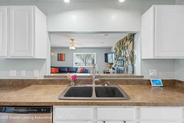 kitchen with a sink, ceiling fan, dishwasher, white cabinets, and open floor plan