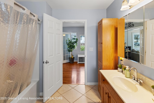bathroom featuring tile patterned floors, shower / tub combo, vanity, and baseboards