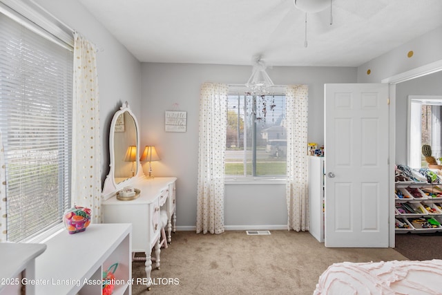 bedroom featuring a ceiling fan, visible vents, light colored carpet, and baseboards