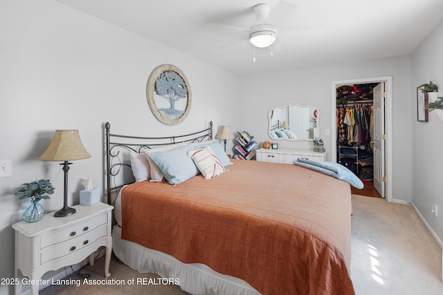 bedroom featuring baseboards, a closet, carpet, a spacious closet, and a ceiling fan