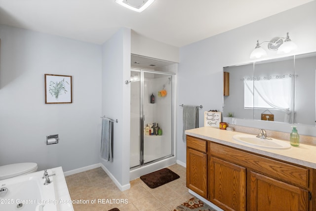 bathroom featuring tile patterned floors, toilet, vanity, baseboards, and a stall shower