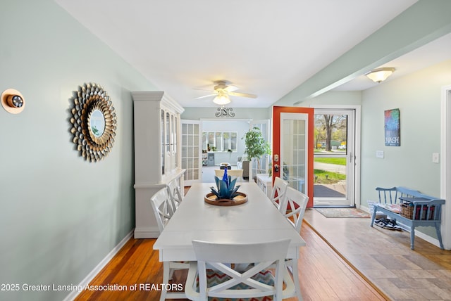 dining area with baseboards, ceiling fan, french doors, and wood-type flooring