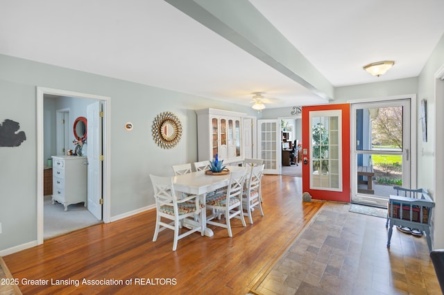 dining space featuring baseboards, wood finished floors, a ceiling fan, and french doors