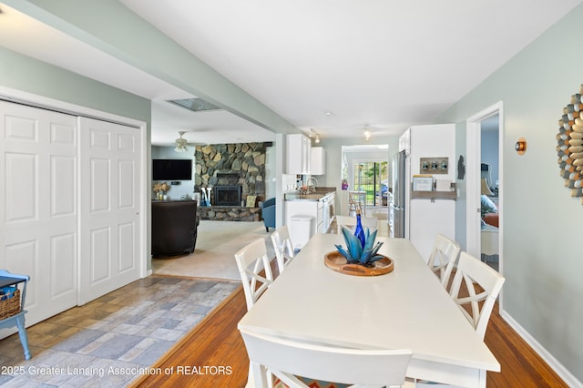 dining space with a fireplace and a ceiling fan
