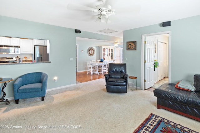 living room featuring carpet, a ceiling fan, and baseboards
