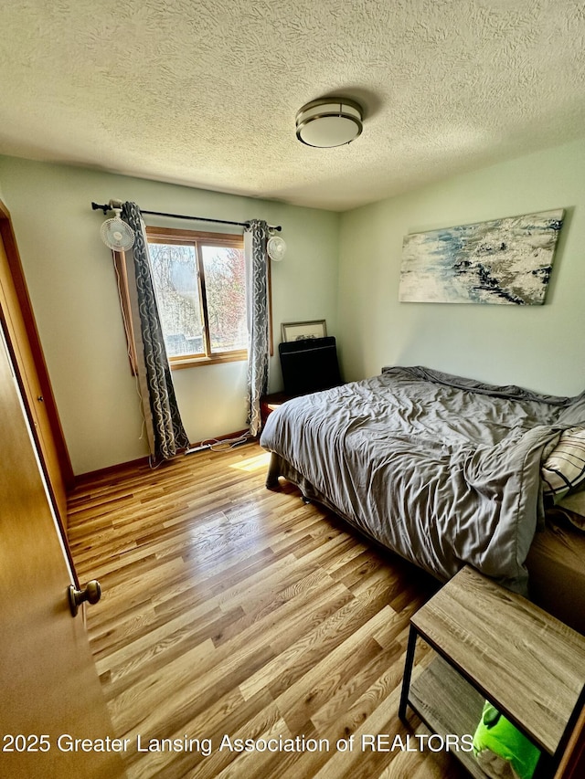 bedroom featuring wood finished floors and a textured ceiling