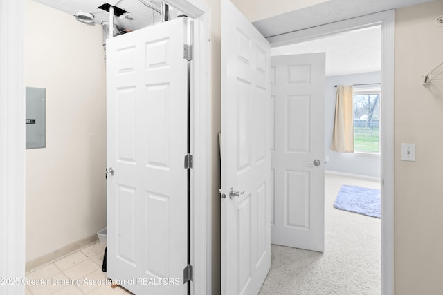hallway with baseboards and electric panel