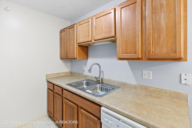 kitchen with light countertops, a textured ceiling, a sink, and dishwasher