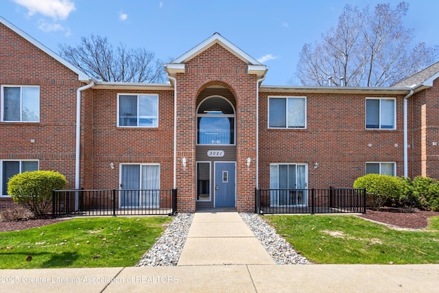 view of front of property with brick siding and fence private yard
