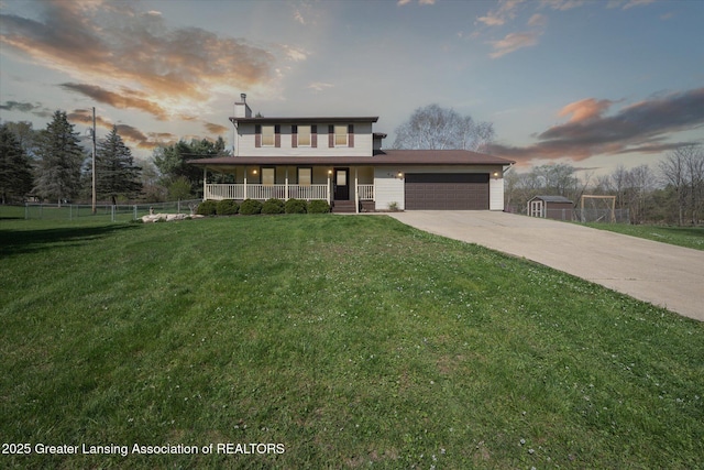 view of front of house featuring covered porch, an attached garage, driveway, and a front lawn