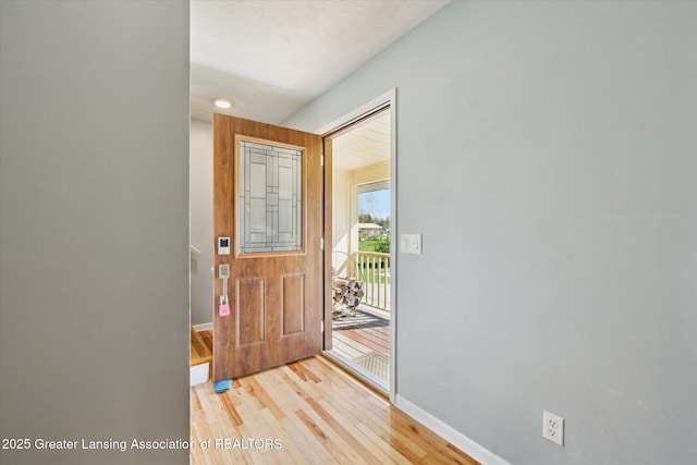 foyer with baseboards and light wood-style flooring