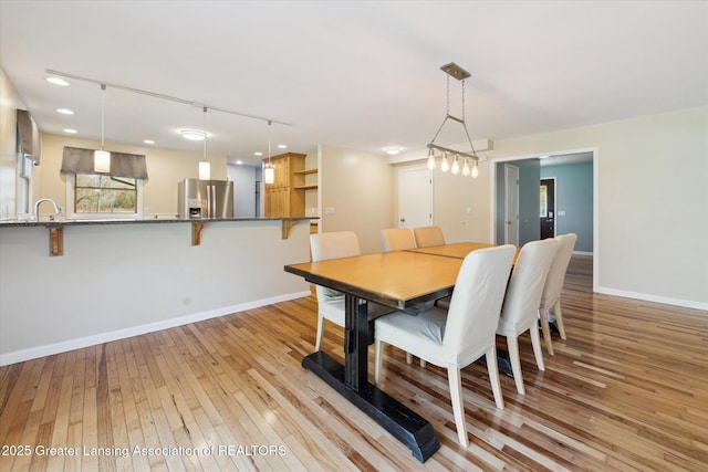 dining room with recessed lighting, baseboards, and light wood-style flooring