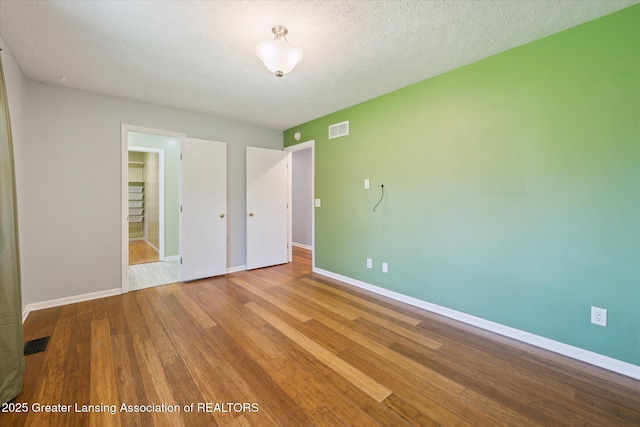 interior space with baseboards, visible vents, and wood finished floors