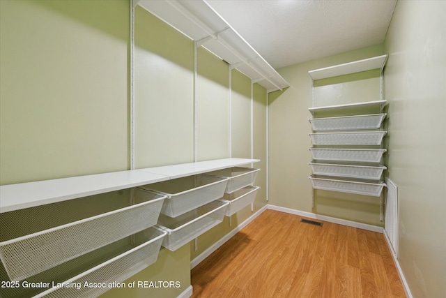 spacious closet with visible vents and wood finished floors