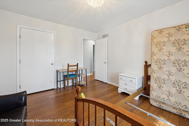 bedroom with visible vents and wood finished floors