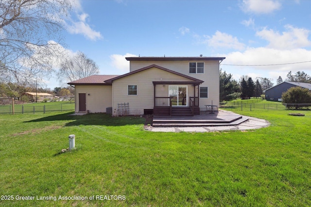 back of property featuring fence, a yard, and a wooden deck