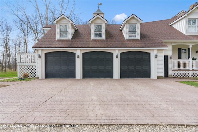 1785 N Williamston Rd, Williamston, MI 48895 - garage featuring a porch and decorative driveway