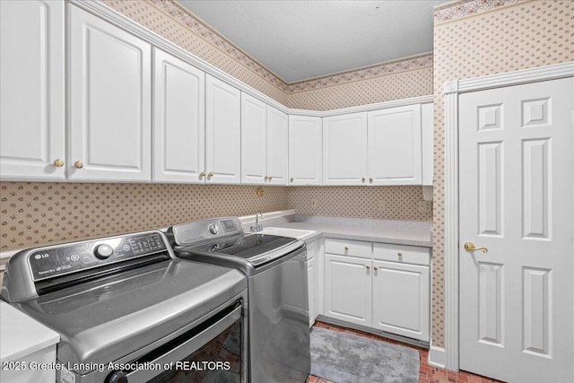 1785 N Williamston Rd, Williamston, MI 48895 - laundry room featuring wallpapered walls, cabinet space, a sink, a textured ceiling, and washer and clothes dryer