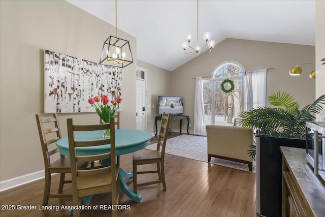 1785 N Williamston Rd, Williamston, MI 48895 - dining room featuring lofted ceiling, a chandelier, hardwood / wood-style flooring, and baseboards