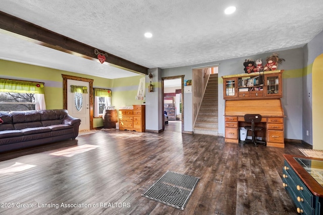 living room with a textured ceiling, plenty of natural light, stairway, and dark wood-style flooring