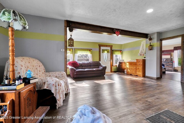 bedroom featuring recessed lighting, wood finished floors, beam ceiling, visible vents, and a textured ceiling