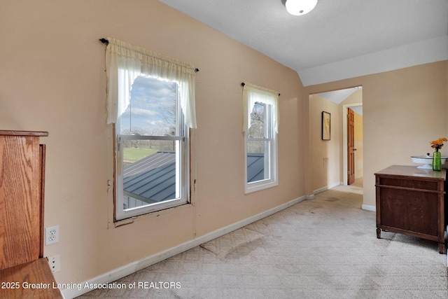 interior space featuring lofted ceiling and baseboards
