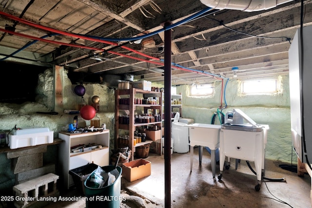 below grade area featuring separate washer and dryer and a sink