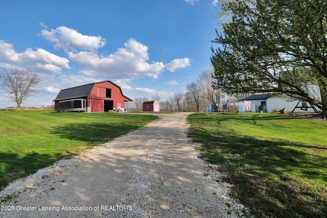view of road with a barn and driveway