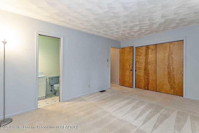 unfurnished bedroom featuring carpet flooring, baseboards, and connected bathroom