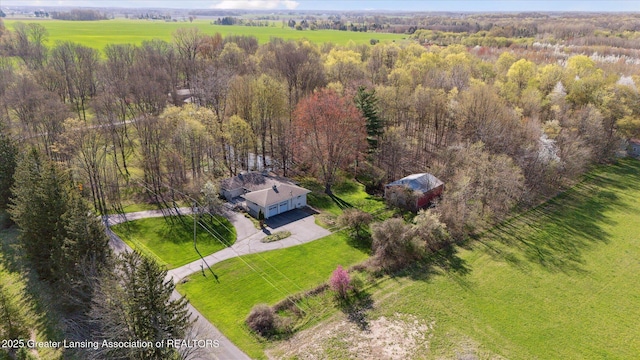 drone / aerial view featuring a view of trees and a rural view