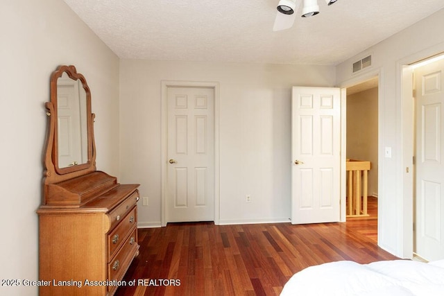 unfurnished bedroom with baseboards, dark wood-style flooring, and visible vents