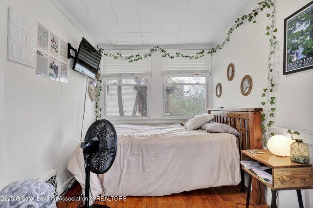 bedroom featuring crown molding, visible vents, and hardwood / wood-style floors