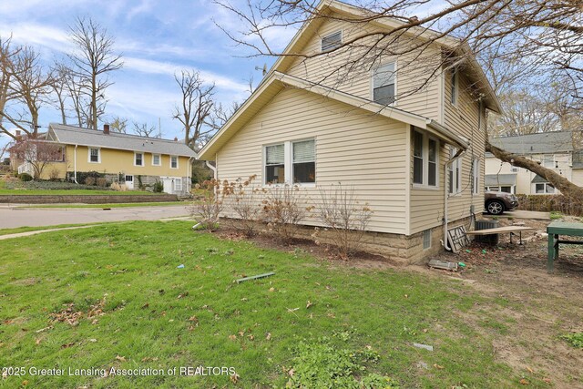 view of side of home with a yard