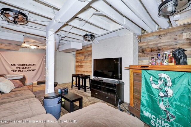 living area with wood finished floors and wooden walls