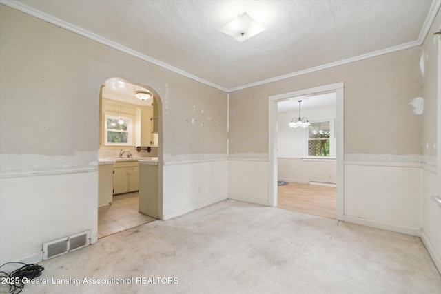 12102 Rupp Rd, Grand Ledge, MI 48837 - unfurnished room with crown molding, a chandelier, arched walkways, light carpet, and a sink