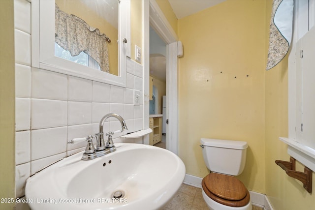 12102 Rupp Rd, Grand Ledge, MI 48837 - half bathroom with a sink, toilet, backsplash, baseboards, and tile patterned flooring