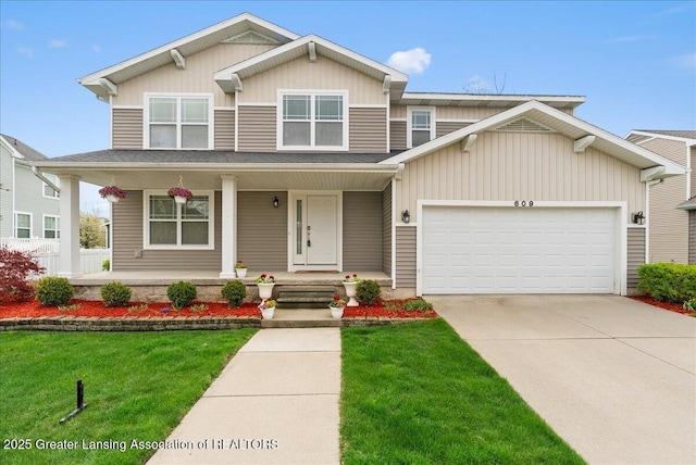 609 E Avocet Dr, East Lansing, MI 48823 - view of front facade with a porch, an attached garage, concrete driveway, and a front lawn