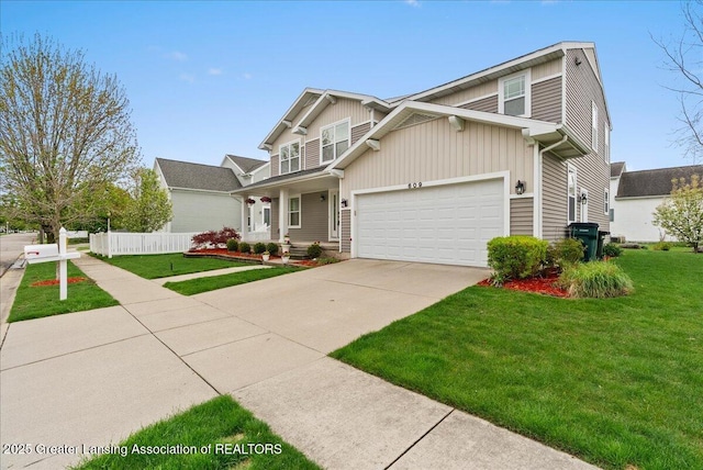 609 E Avocet Dr, East Lansing, MI 48823 - view of front facade featuring concrete driveway, a garage, and board and batten siding