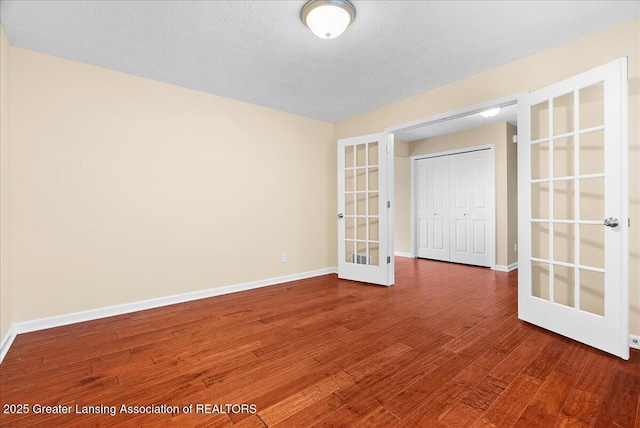 609 E Avocet Dr, East Lansing, MI 48823 - empty room featuring french doors, wood finished floors, and baseboards
