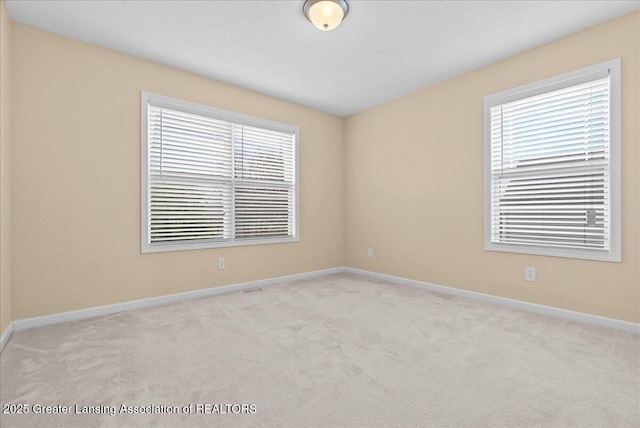609 E Avocet Dr, East Lansing, MI 48823 - carpeted empty room featuring healthy amount of natural light and baseboards