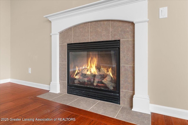 609 E Avocet Dr, East Lansing, MI 48823 - detailed view of wood finished floors, a fireplace, and baseboards