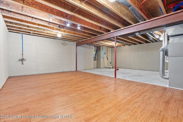 609 E Avocet Dr, East Lansing, MI 48823 - unfinished basement featuring wood finished floors, electric panel, and heating unit