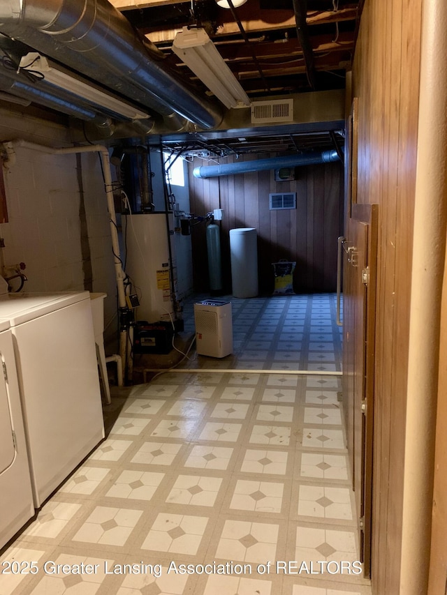 3156 E M-21 Rd, Saint Johns, MI 48879 - unfinished basement featuring water heater, light floors, washer and dryer, visible vents, and wooden walls