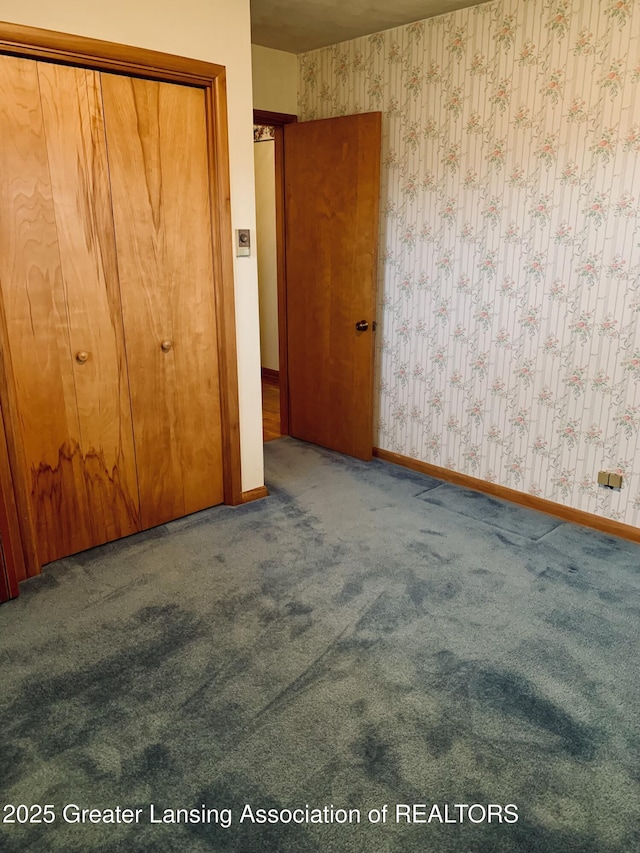 3156 E M-21 Rd, Saint Johns, MI 48879 - unfurnished bedroom featuring baseboards, wallpapered walls, and carpet floors