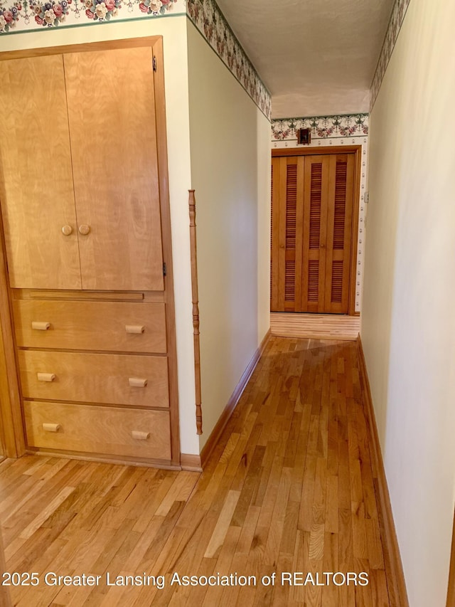3156 E M-21 Rd, Saint Johns, MI 48879 - hall featuring light wood-style flooring, wallpapered walls, and baseboards