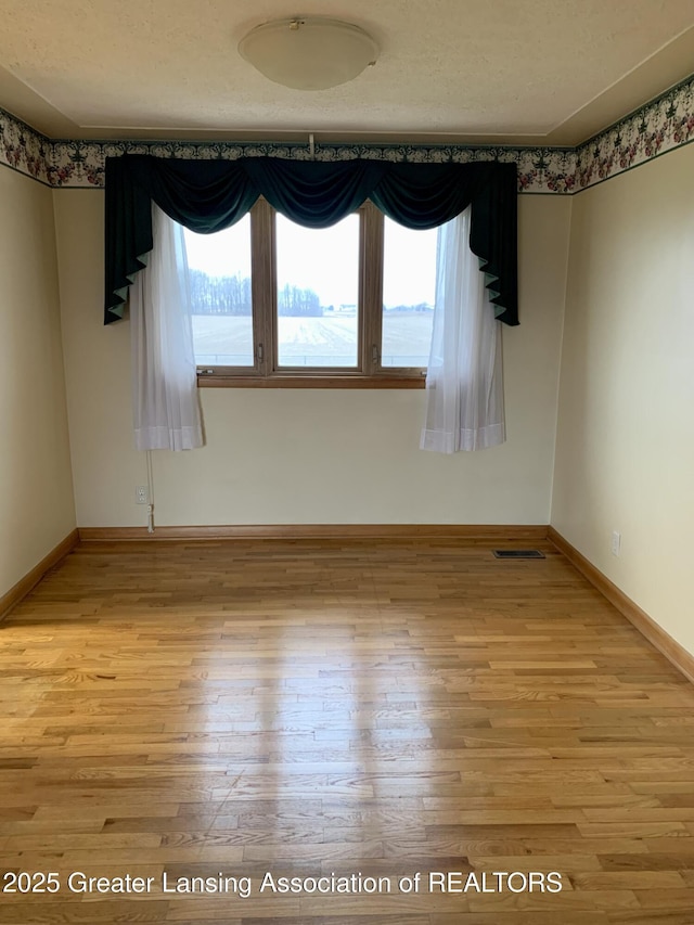 3156 E M-21 Rd, Saint Johns, MI 48879 - spare room with light wood-style floors, visible vents, and baseboards