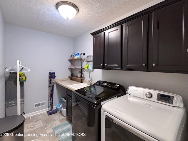 2718 Kittansett Dr, Okemos, MI 48864 - washroom featuring cabinet space, washing machine and clothes dryer, baseboards, and a textured ceiling
