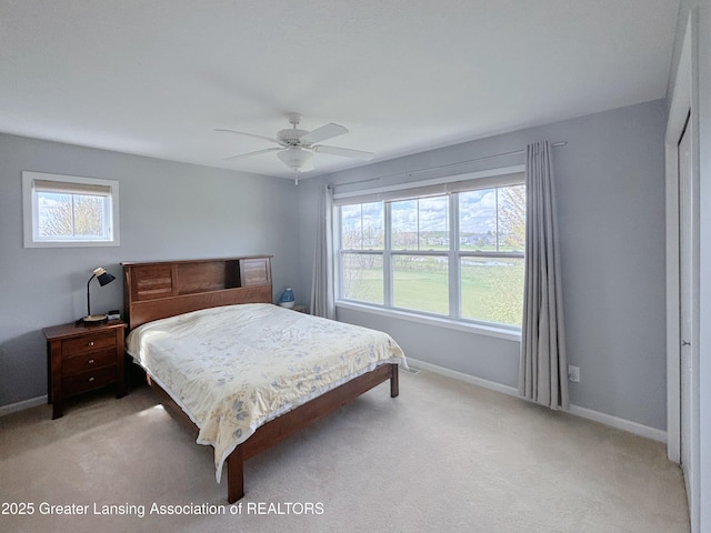 2718 Kittansett Dr, Okemos, MI 48864 - bedroom with multiple windows, baseboards, light colored carpet, and ceiling fan