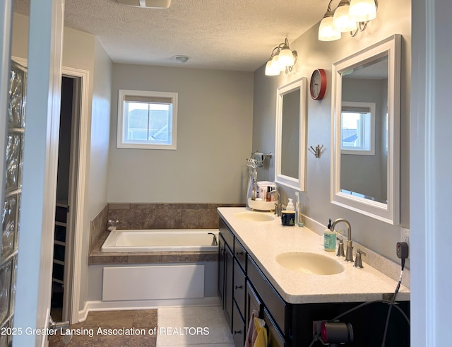 2718 Kittansett Dr, Okemos, MI 48864 - bathroom with a garden tub, a textured ceiling, and double vanity