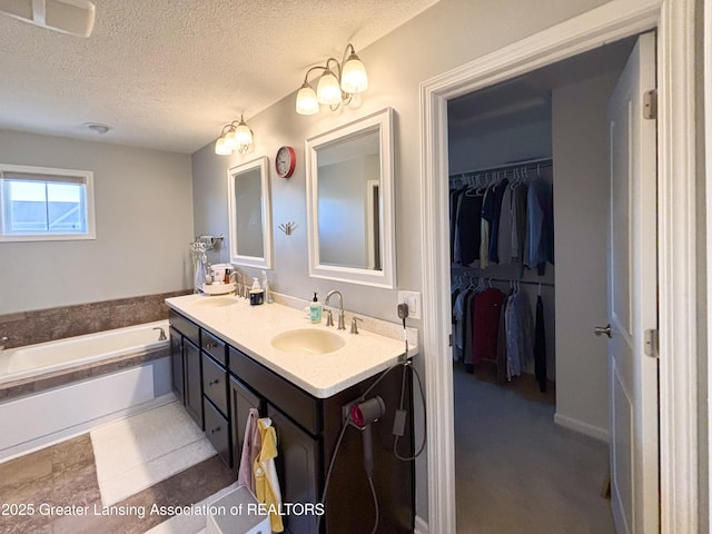 2718 Kittansett Dr, Okemos, MI 48864 - full bath with a textured ceiling, a garden tub, double vanity, and a walk in closet